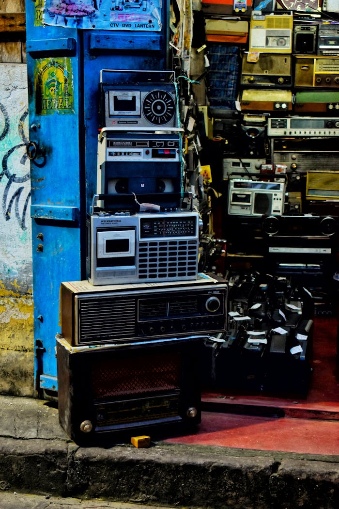 services-04 A collection of vintage radios and electronics stacked in a retro shop for nostalgic vibes.